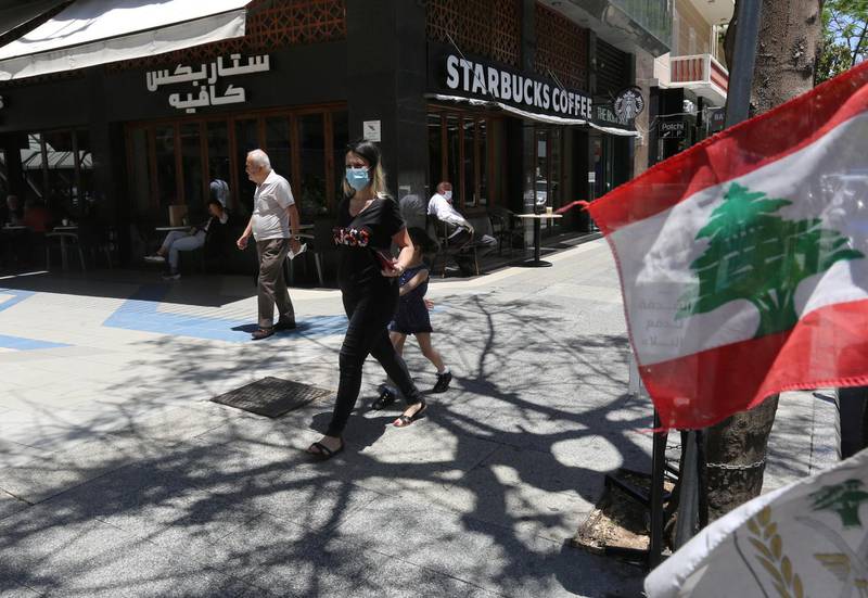 A woman wearing a protective face mask walks past a Starbucks coffee shop in Hamra street, Beirut, Lebanon. Reuters