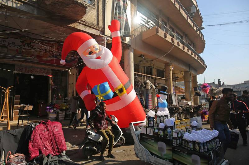 An inflatable Santa Claus is displayed outside a shop in Baghdad's Tahrir  Square.  AFP