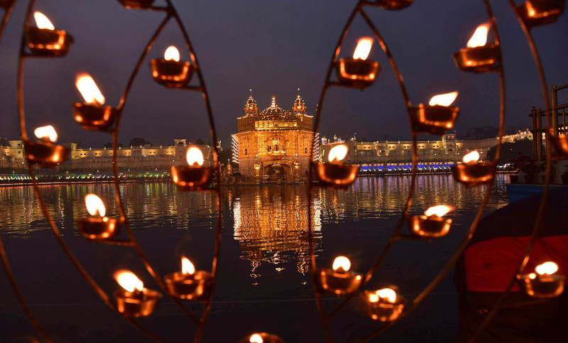 Lamps lit by devotees shine in front of the illuminated Golden Temple, the holiest of Sikh shrines, on the birth anniversary of Guru Nanak in Amritsar, India. AP Photo