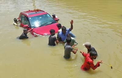 People pull a car on a waterlogged road following torrential rains in Bengaluru, India. Reuters