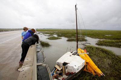 Hurricane watchers look over the Isle of Palms connector at a sailboat that came loose during Hurricane Dorian at the Isle of Palms, S.C.in Charleston, S.C. AP