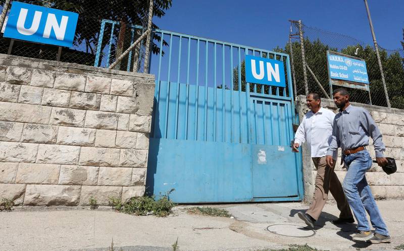Palestinians pass by the gate of an UNRWA-run school in Nablus in the occupied West Bank August 13, 2018. Picture taken August 13, 2018. REUTERS/Abed Omar Qusini