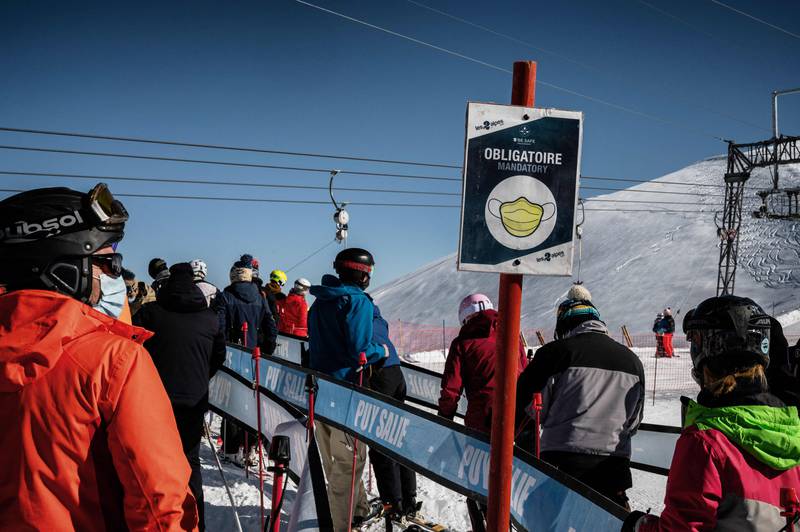 People wear protective face masks while queuing for ski lifts in France. AFP