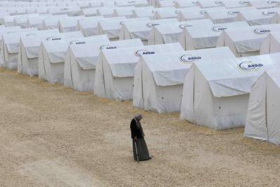 A Kurdish refugee woman from the Syrian town of Kobani walks along tents at a refugee camp in the border town of Suruc, Sanliurfa province.  Umit Bektas / Reuters