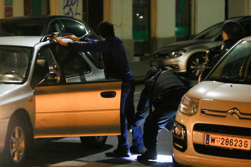 Police officers check a person after gunshots were heard, in Vienna. Ronald Zak