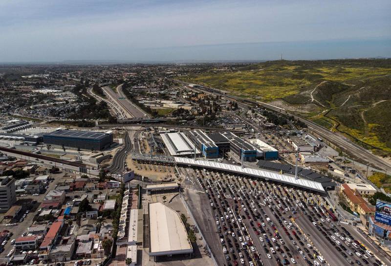 Aerial view of cars waiting to cross the San Ysidro Port of Entry bording crossing that connects the US-Mexico border cities of San Diejo and Tijuana seen from Tijuana, in Baja California state, Mexico, on March 29, 2019.  President Donald Trump on Friday again accused Mexico of failing to curb the flow of migrants illegally entering the US, and threatened to close the common border "next week" unless something changes. Trump's latest tweets ramp up the tension between the neighbors, putting a specific timeframe to his threats to shut the border, one of the busiest in the world. / AFP / Guillermo Arias
