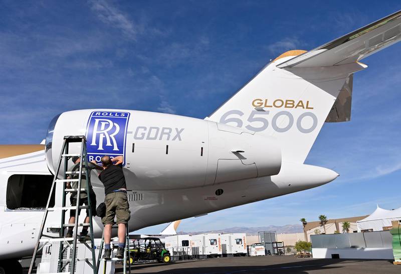 FILE PHOTO: Workers apply a Rolls Royce decal to the engine of a Bombardier Global 6500 business jet at the Bombardier booth at the National Business Aviation Association (NBAA) exhibition in Las Vegas, Nevada, U.S. October 21, 2019.  REUTERS/David Becker/File Photo