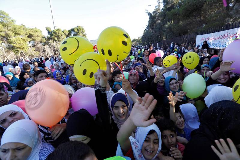 Children race to get balloons during Eid Al Fitr celebrations in Amman. Reuters
