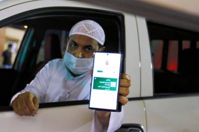 A Saudi national shows his vaccination certificate on his smart phone as he enters Bahrain. Reuters