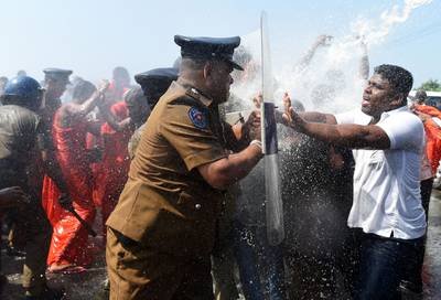 Sri Lankan police use water canons to disperse activists and Buddhist monks clash during a protest in the southern port city of Hambantota on January 7, 2017.  Sri Lankan nationalists, monks and local residents are protesting the creation of an industrial zone for Chinese investments on the island.  / AFP / Ishara S. KODIKARA