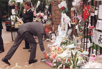 Prince William places a bunch of flowers with the hundreds tributes already laid outside his mother's official residence at Kensington Palace, in 1997. AFP