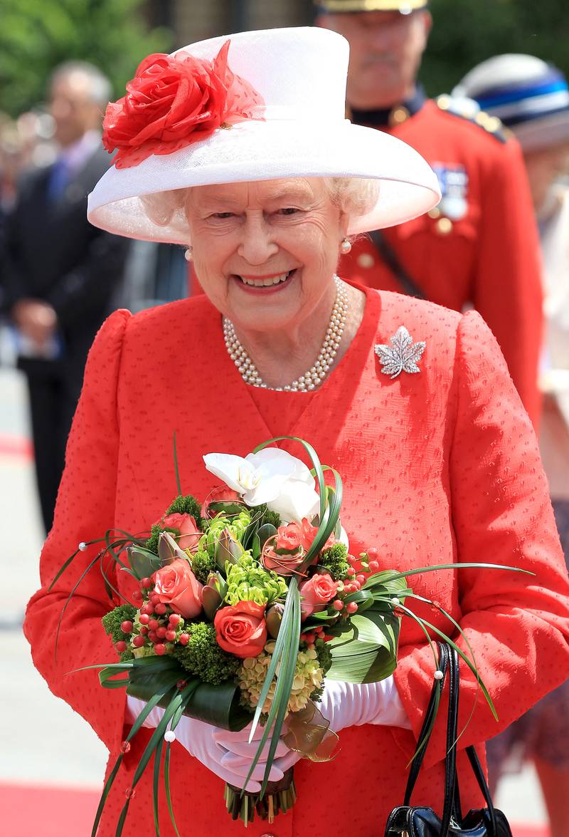 Queen Elizabeth II, wearing a red dress and her Canadian Maple Leaf Royal Brooch, arrives for Canada Day celebrations in Ottawa, Canada on July 1, 2010. AFP 