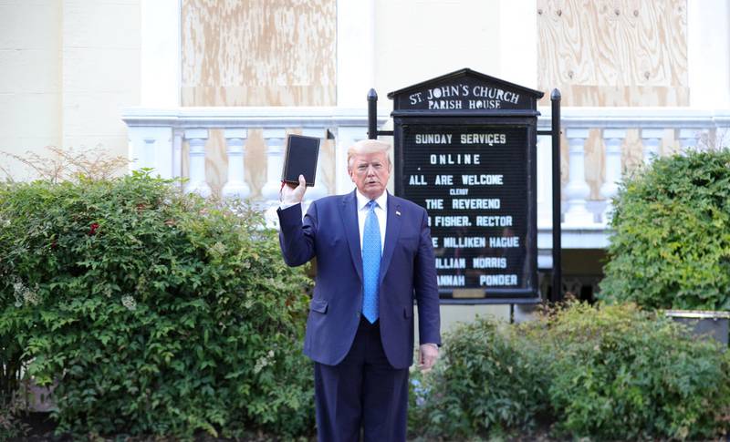 US President Donald Trump holds up a Bible as he stands in front of St. John's Episcopal Church across from the White House after walking there for a photo opportunity during ongoing protests over racial inequality in the wake of the death of George Floyd, on June 1, 2020. Reuters
