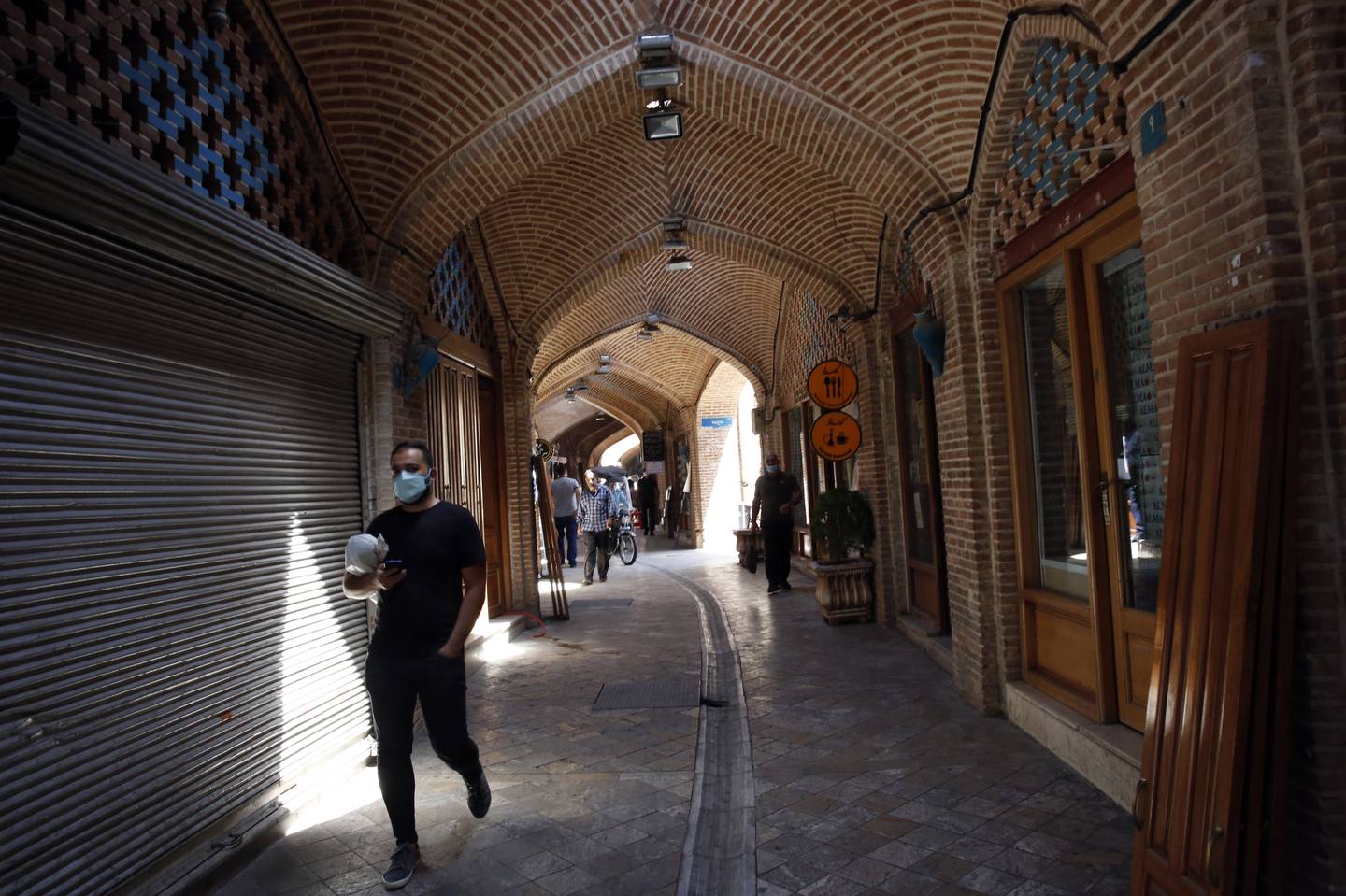 Iranians walk next to closed shops in Tehran's bazaar. EPA