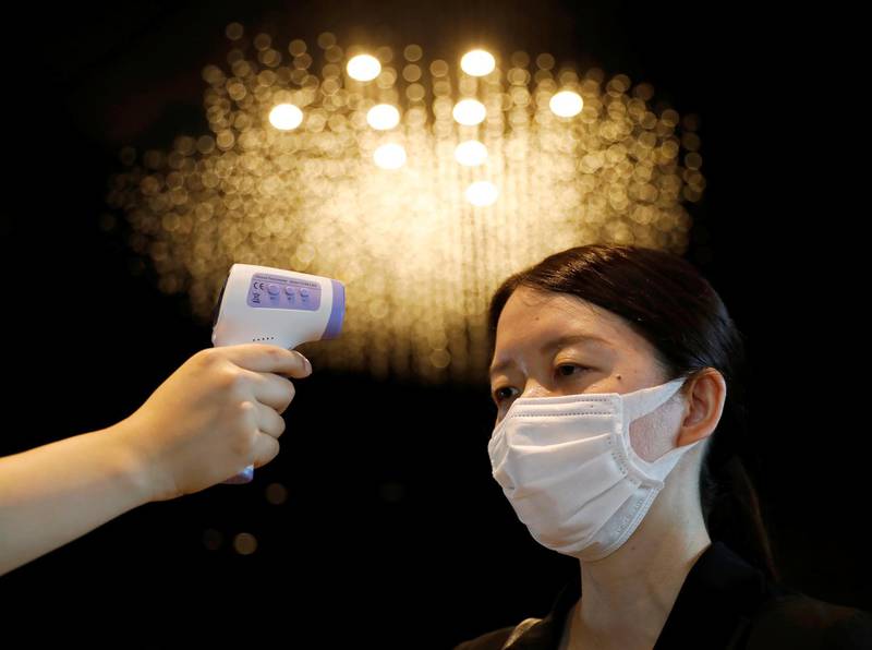 A woman has her temperature checked by a hotel worker in Tokyo, Japan. Reuters