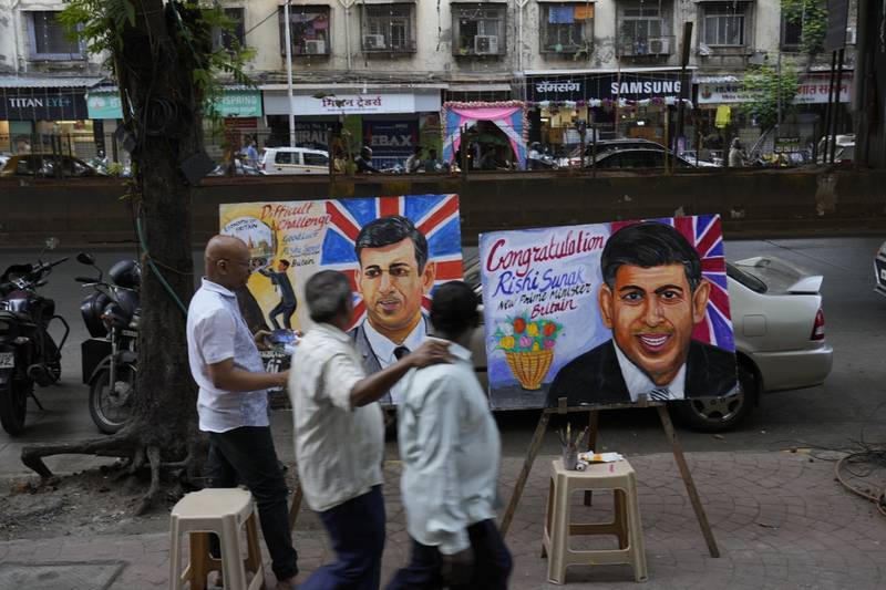 An artist paints a picture of British Prime Minister Rishi Sunak in Mumbai, India. AP