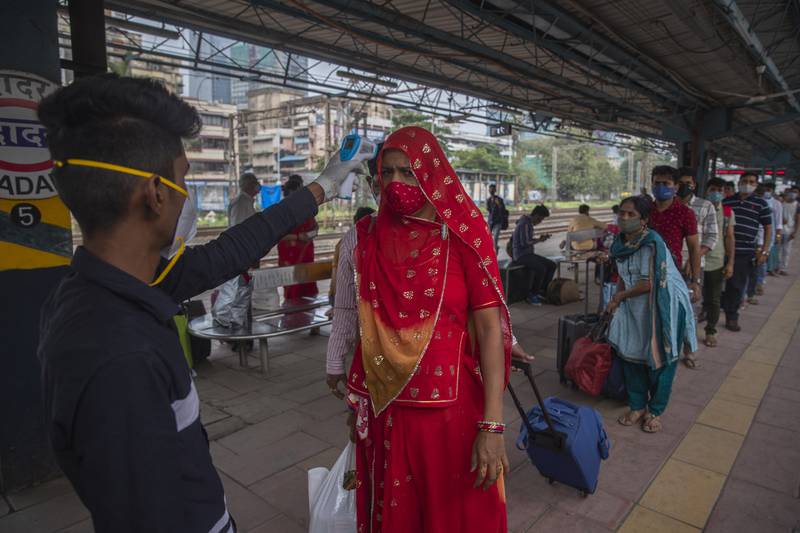 This passenger was allowed to proceed after having her temperature tested at the Mumbai train station.  AP Photo