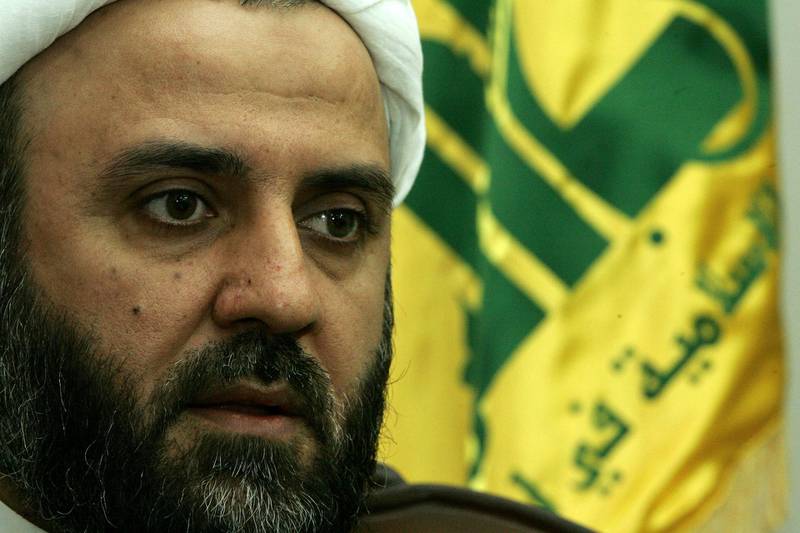(FILES) In this file photo taken on November 20, 2006, Sheikh Nabil Qawuq, Hezbollah's military chief in south Lebanon, sits in front of the militia's flag in Tyre. / AFP / Ramzi HAIDAR
