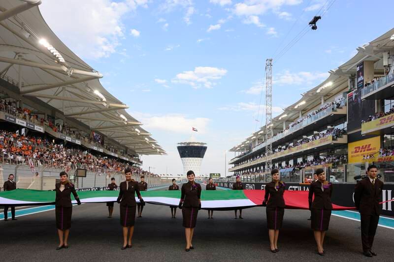 Etihad crew members hold the UAE flag before the race. Photo: Abdulla Al Neyadi /  UAE Presidential Court