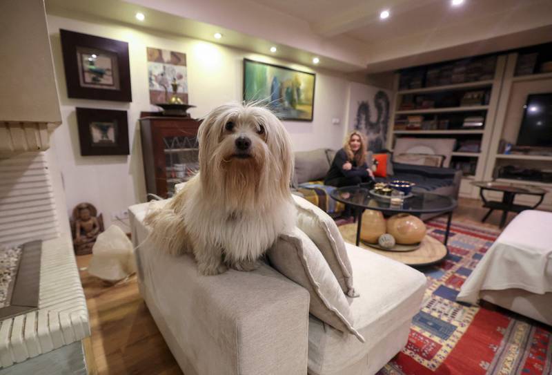An Iranian woman sits with her dog at home in northern Tehran, on December 5, 2021.  - A proposed law to ban pets submitted by ultraconservative Iranian lawmakers, pits growing numbers of people with pets against those who consider the practice decadent and hold that under Islamic law dogs, like pigs, are unclean.  The bill has sparked criticism in the press, mockery on social networks and anger among residents of the capital.  (Photo by ATTA KENARE  /  AFP)
