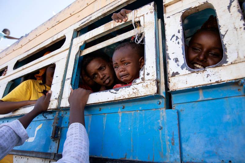Refugees who fled the conflict in Ethiopia's Tigray region ride a bus going to the Village 8 temporary shelter, near the Sudan-Ethiopia border, in Hamdayet, eastern Sudan, on Dec. 1, 2020. (AP Photo/Nariman El-Mofty)