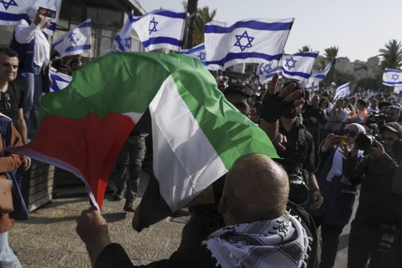 A Palestinian waves his national flag outside Jerusalem's Old City as Israelis mark Jerusalem Day, which celebrates the capture of the Old City during the 1967 war. AP