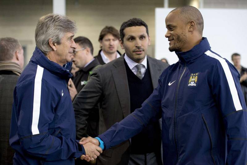The then Manchester City manager, Manuel Pellegrini, chairman Khaldoon Al Mubarak, centre, and captain Vincent Kompany, right, greet at the opening of the City Football Academy in Manchester on Monday. AFP