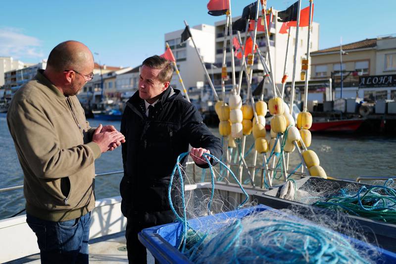 Far-right party Debout La France presidential candidate Nicolas Dupont-Aignan speaks to a fisherman in Palavas-les-Flots, southern France. AFP