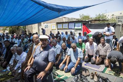 Men gather for a protest support prayer on the road outside the Shamasneh home for Friday noon prayer   in the East Jerusalem neighborhood of Sheik Jarrah on August 11,2017.

When the Shamasne family first moved into their home  in the 1960s, East Jerusalem was controlled by Jordan and their monthly rent was paid to  Jordanian authorities but since  Israel annexed East Jerusalem in 1967, the Shamasne family has paid their rent to Israel's general custodian in order to remain in the building.
The family claims that their payments were suddenly rejected in 2009 , and they were informed that the property had been claimed by Israeli Jews whose ancestors had lived there decades previously.Although the family has spent years fighting to remain in the home , the Israeli high court has ruled that the family must evacuate the home before August 9. (Photo by Heidi Levine for The National).