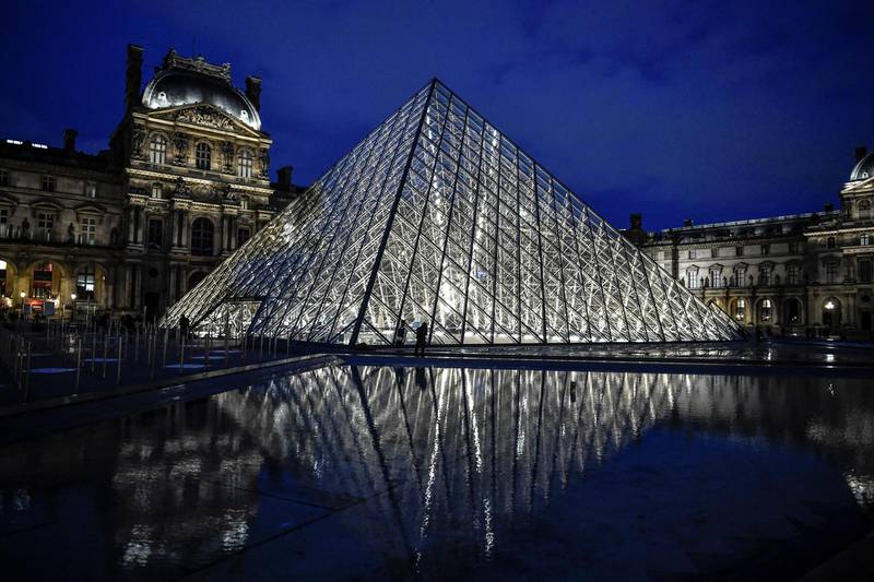 This photograph taken on October 29, 2020 in Paris shows an exterior view of the Musee du Louvre at its closing time and the Pyramide du Louvre, designed by Ieoh Ming Pei, ahead of a second national general lockdown from October 30 to December 1, aimed at curbing the spread of Covid-19. - France and Germany have moved toward shutting down sectors of their economies as part of accelerating efforts worldwide to check a resurgent coronavirus and still limit the financial fallout. (Photo by STEPHANE DE SAKUTIN / AFP) / RESTRICTED TO EDITORIAL USE - MANDATORY MENTION OF THE ARTIST UPON PUBLICATION - TO ILLUSTRATE THE EVENT AS SPECIFIED IN THE CAPTION
