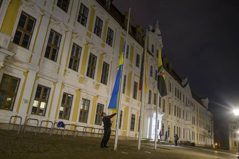 A police officer raises the Ukrainian flag in front of the state parliament of Saxony-Anhalt in Magdeburg, Germany. AP