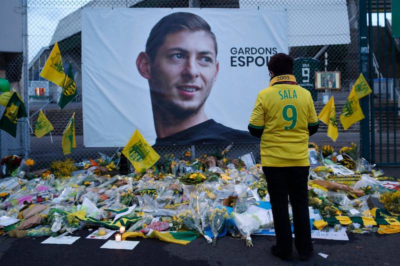 FILE - In this Wednesday, Jan. 30, 2019, file photo, a Nantes soccer team supporters stops by a poster of Argentinian player Emiliano Sala and reading "Let's keep hope" outside La Beaujoire stadium before the French soccer League One match Nantes against Saint-Etienne, in Nantes, western France. On Sunday, Feb. 3, 2019, the man leading a private search for the missing plane carrying Argentine soccer player Emiliano Sala says the wreckage has been found. (AP Photo/Thibault Camus, File)