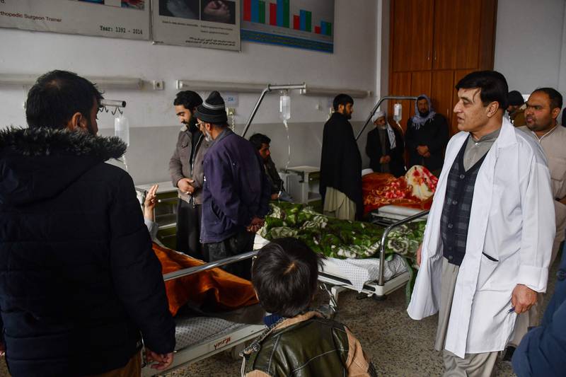 Relatives visit Afghan men receiving treatment at a hospital after they were wounded when a roadside bomb hit a bus carrying employees of a petroleum company in Mazar-i- Sharif on December 6, 2022. AFP