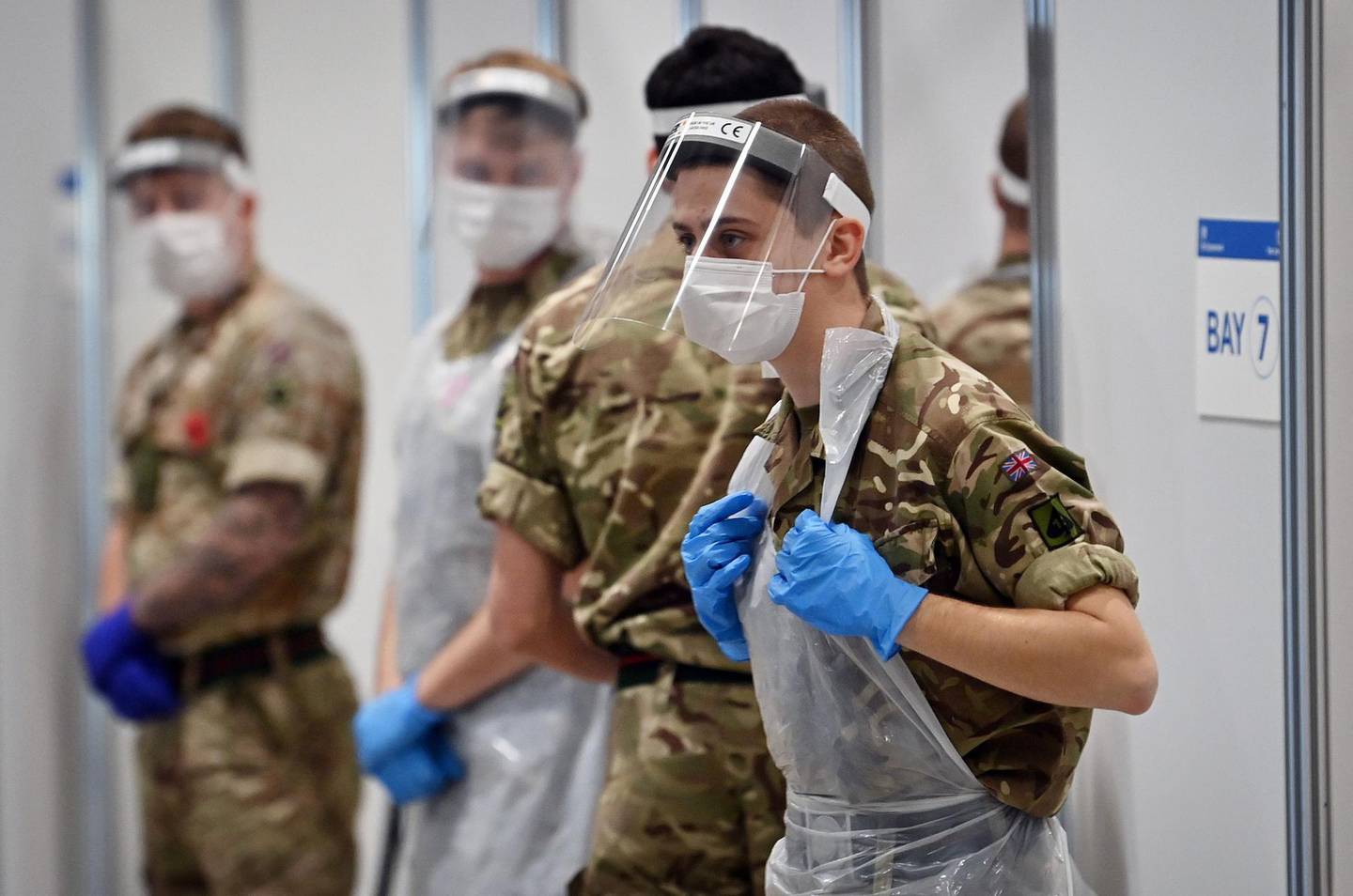 Soldiers wearing full PPE (personal protective equipment) in the form of face shields, gloves, face masks and bibs wait to assist covid testing at a coronavirus rapid testing centre in the Liverpool exhibition centre in Liverpool, north-west England on November 11, 2020, during a city-wide mass testing pilot operation.  Liverpool on November 6 began England's first city-wide trial of coronavirus testing in an attempt to prevent hospitals becoming overwhelmed during the country's second wave of the pandemic. All of the northwestern city's 500,000 residents as well as people working there will be offered repeat tests, even if asymptomatic, under the pilot trial, which will initially run for two weeks.


 / AFP / Paul ELLIS
