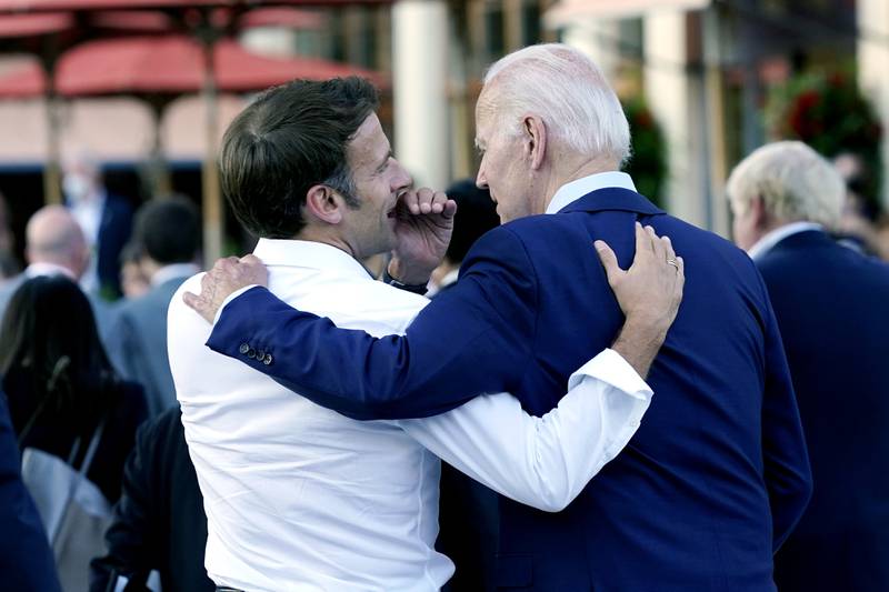 French President Emmanuel Macron whispers to US President Joe Biden following their dinner at the G7 Summit in Elmau, Germany, in June. AP