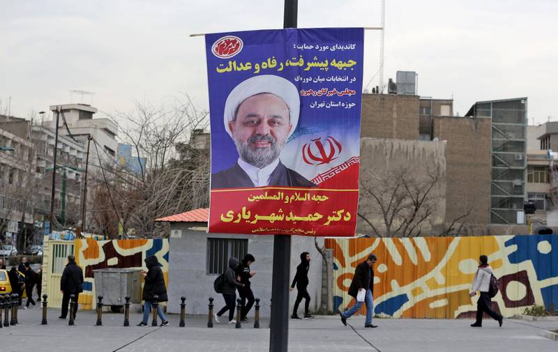Iranians walk past electoral posters and fliers during the last day of election campaign in the capital Tehran. AFP