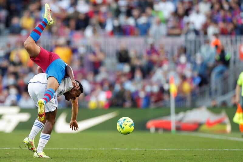 Barcelona defender Sergino Dest goes tumbling after a clash with Real Madrid winger Vinicius Jr. EPA
