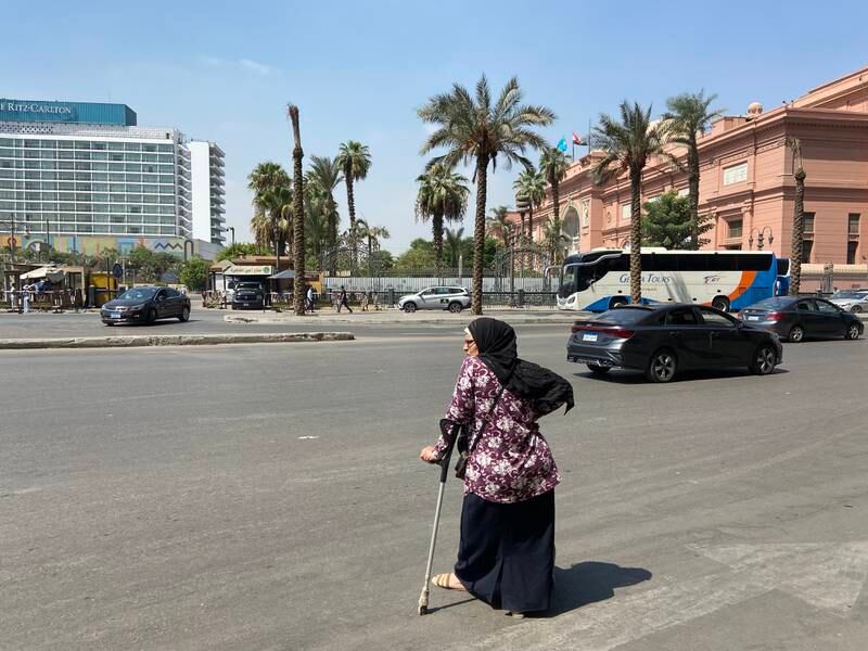 A woman waits for a bus to take her to Ramses train station. 