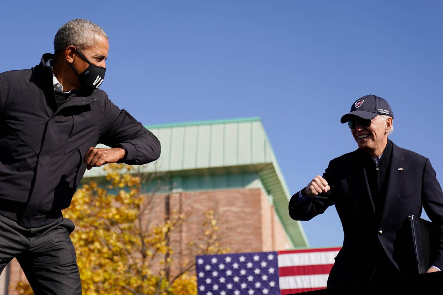 Democratic presidential candidate former Vice President Joe Biden, right, and former President Barack Obama greet each other with an air elbow bump, at the conclusion of rally at Northwestern High School in Flint, Mich., Saturday, Oct. 31, 2020. (AP Photo/Andrew Harnik)