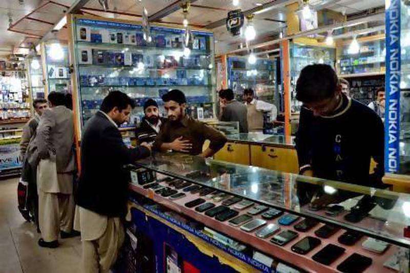 Shopkeepers and clients at a mobile market in Peshawar. Pakistan's mobile telecoms market has become highly competitive. A Majeed / AFP