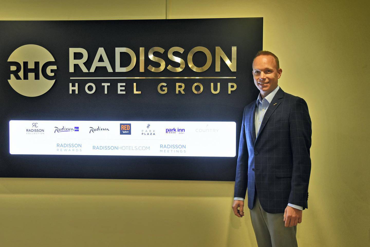 Tim Cordon, area senior vice president of Radisson Hotel Group for Middle East & Africa poses for a photograph in front of the Radisson Hotel Group logo at his office in Dubai, UAE, Monday, July 1, 2019. (Photos by Shruti Jain/The National)