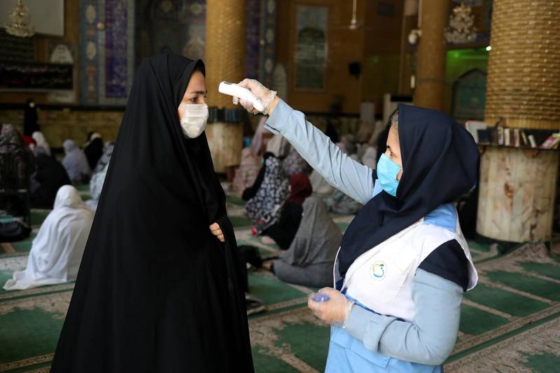 An Iranian woman wearing a protective face mask checks the temperature of a worshipper before attending the Friday prayers in Qarchak Jamee Mosque, following the outbreak of the coronavirus disease (COVID-19), in Tehran province, in Qarchak, Iran, June 12, 2020. WANA (West Asia News Agency)/Ali Khara via REUTERS ATTENTION EDITORS - THIS PICTURE WAS PROVIDED BY A THIRD PARTY