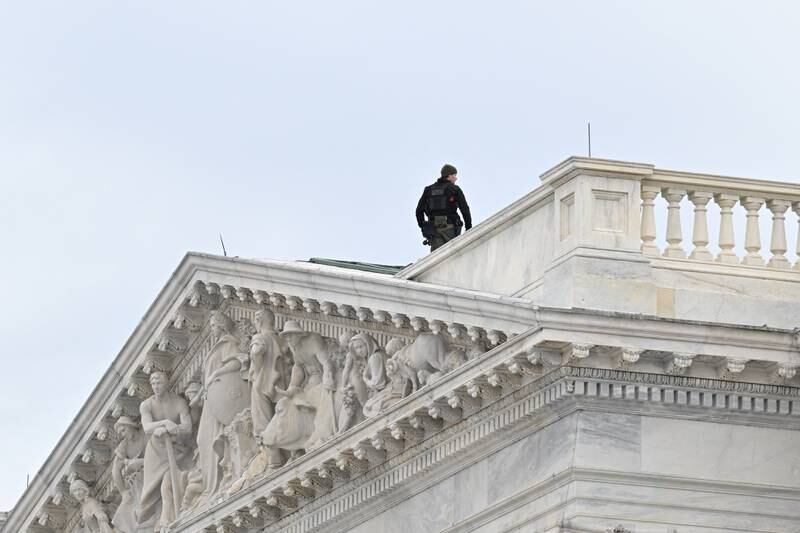 A Capitol Police officer stands on the roof. Reuters