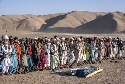 Afghans pray for relatives at a burial site after an earthquake in Zenda Jan district, Afghanistan. AP