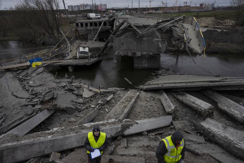 Engineers inspect damage to the bridge that connects Kyiv with Irpin. AP