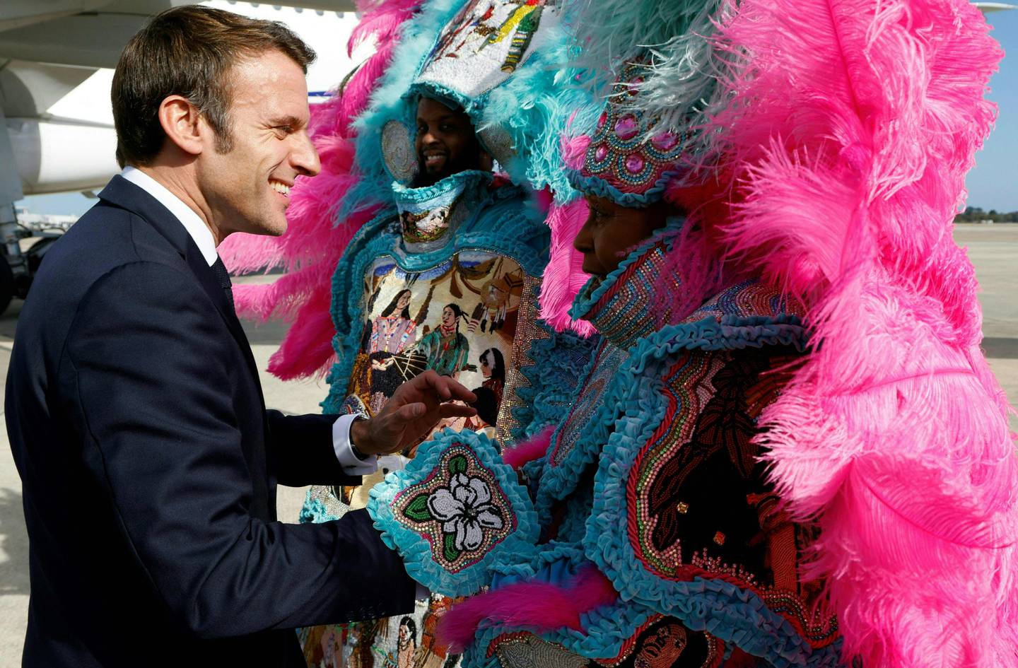 French President Emmanuel Macron is welcomed to New Orleans by a traditional Mardi Gras Indian in full costume. AFP