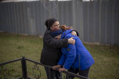 Ira Slepchenko, 54, and Valya Naumenko, 47, embrace as they  mourn the deaths of their husbands, at the exhumation of a mass grave in Bucha, near Kyiv. AP