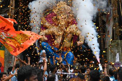 Devotees carry an idol of the elephant-headed Hindu deity 'Ganesha' during a procession along a street in Mumbai. AFP
