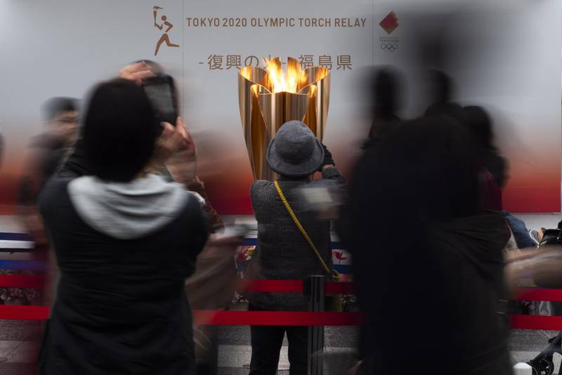 People take pictures of the Olympic Flame during a ceremony in Fukushima City. AP