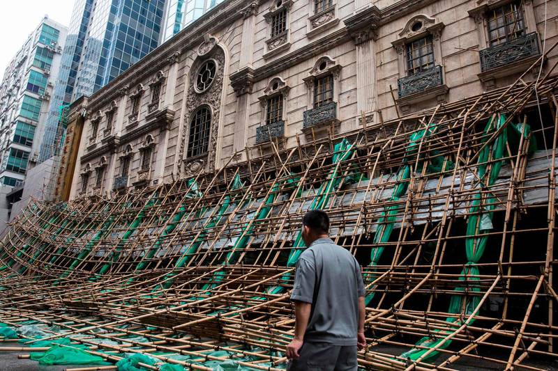 A man stands in front of scaffolding that was brought down by strong winds, a day after Typhoon Mangkhut hit Macau. AFP
